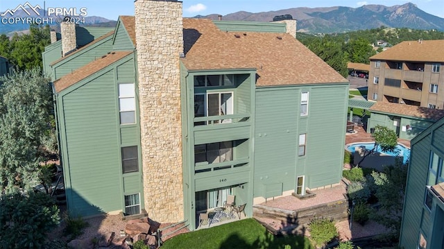 140 W Rockrimmon Blvd Unit 204, Colorado Springs, CO 80919 - rear view of house featuring a shingled roof, a chimney, and a mountain view