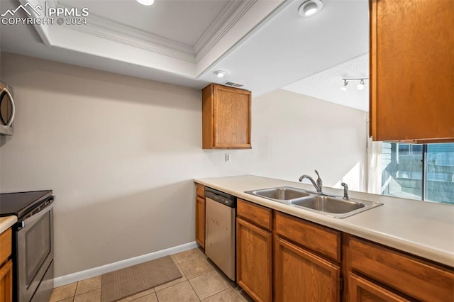 kitchen with crown molding, light tile patterned floors, sink, a tray ceiling, and appliances with stainless steel finishes