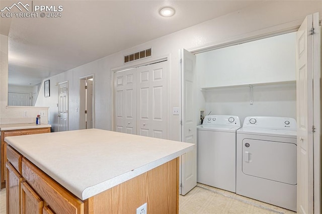 laundry area with light tile patterned floors and washer and clothes dryer