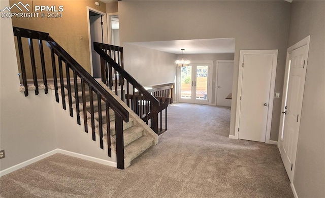 stairs featuring carpet flooring and a notable chandelier