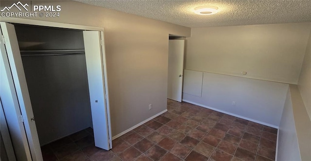 unfurnished bedroom with a textured ceiling and a closet