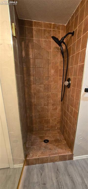 bathroom featuring hardwood / wood-style flooring and tiled shower