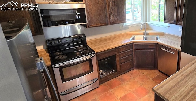 kitchen featuring dark brown cabinetry, stainless steel appliances, and sink