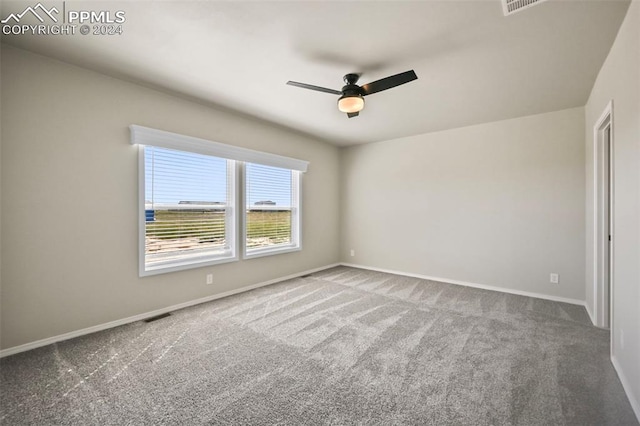 carpeted spare room with ceiling fan