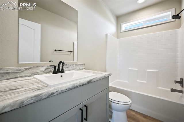 full bathroom featuring vanity, toilet, hardwood / wood-style floors, and shower / tub combination