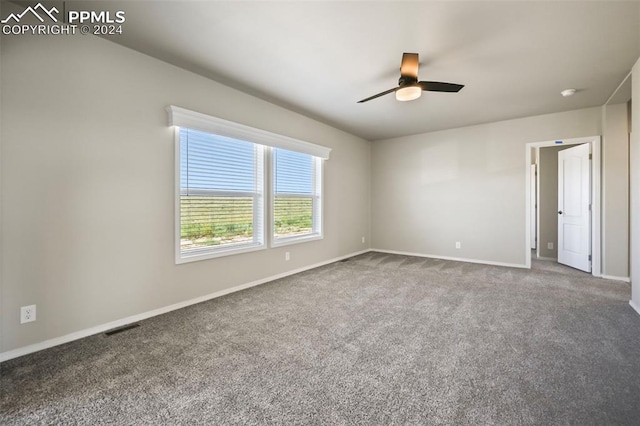 spare room with ceiling fan and carpet