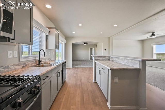 kitchen featuring gray cabinetry, light wood-type flooring, appliances with stainless steel finishes, sink, and ceiling fan