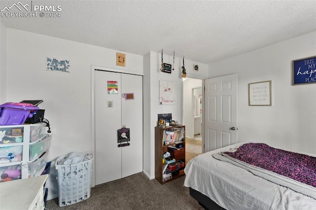 bedroom with a closet, carpet flooring, and a textured ceiling