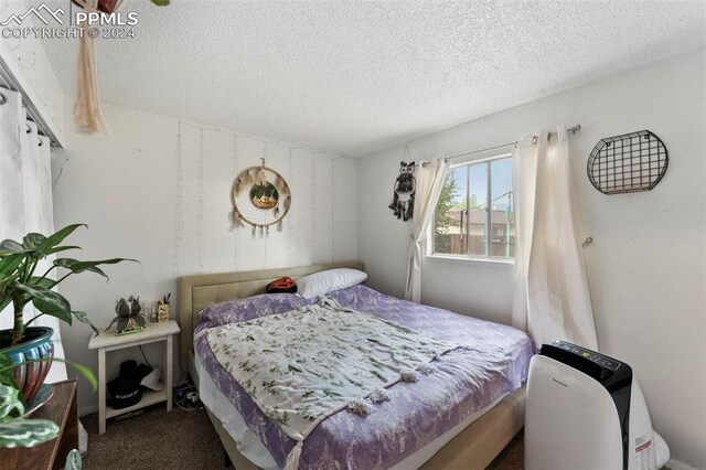 bedroom with a textured ceiling and carpet