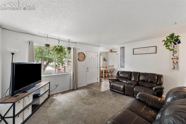 carpeted living room with a textured ceiling and ceiling fan