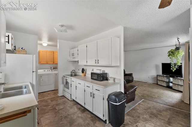 kitchen featuring electric stove, washing machine and dryer, dark tile patterned floors, sink, and white cabinets