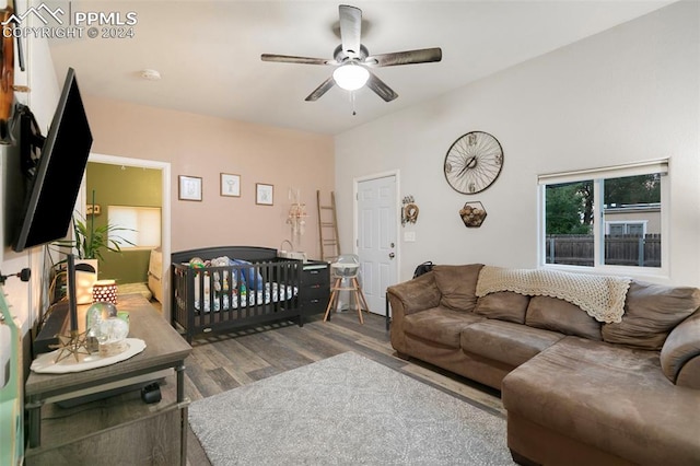 bedroom featuring wood-type flooring, ceiling fan, and a crib