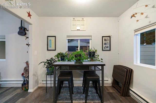 dining space with a baseboard heating unit and dark hardwood / wood-style flooring