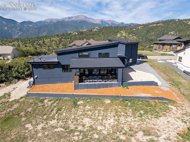 back of property featuring a mountain view and a patio