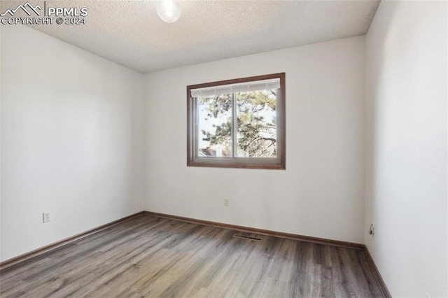 spare room with wood-type flooring and a textured ceiling