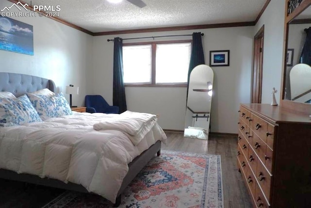 bedroom featuring dark wood-type flooring, crown molding, and a textured ceiling