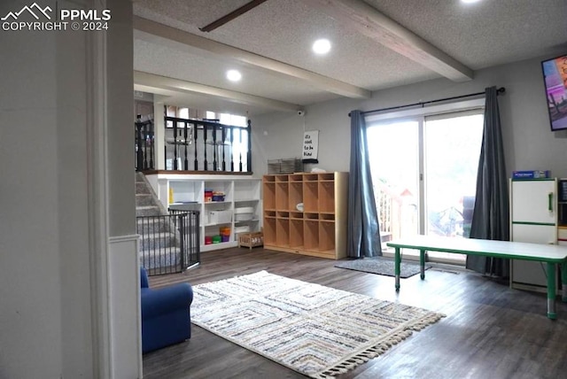 interior space with beamed ceiling, a textured ceiling, and wood-type flooring