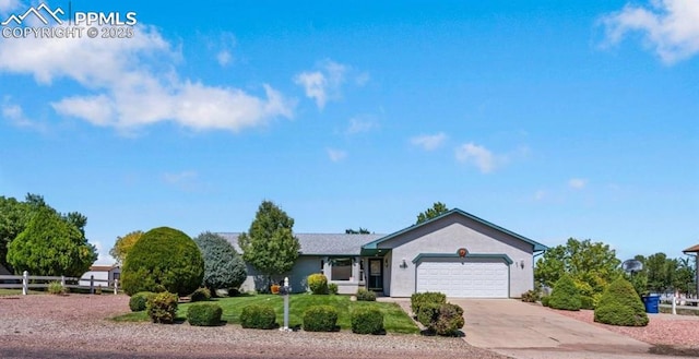 ranch-style house featuring driveway, an attached garage, fence, a front lawn, and stucco siding