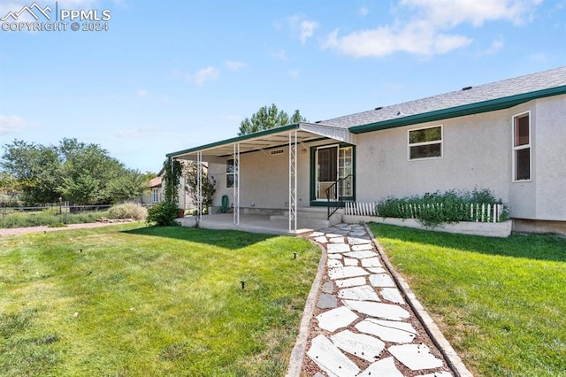 rear view of house with a yard and a patio area