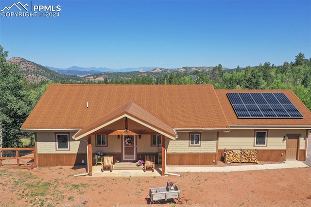 view of front facade featuring a mountain view and solar panels