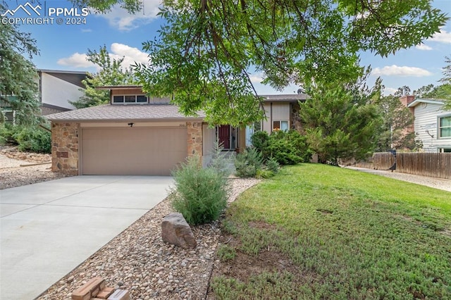 view of front of home with a front yard and a garage