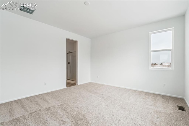 carpeted spare room featuring baseboards and visible vents