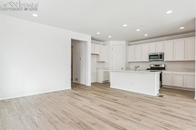 kitchen featuring light wood-style flooring, appliances with stainless steel finishes, white cabinets, and recessed lighting