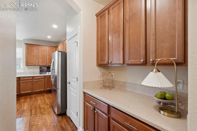 kitchen featuring hardwood / wood-style flooring and stainless steel refrigerator