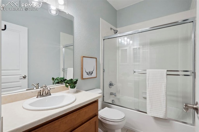 full bathroom featuring combined bath / shower with glass door, vanity, and toilet