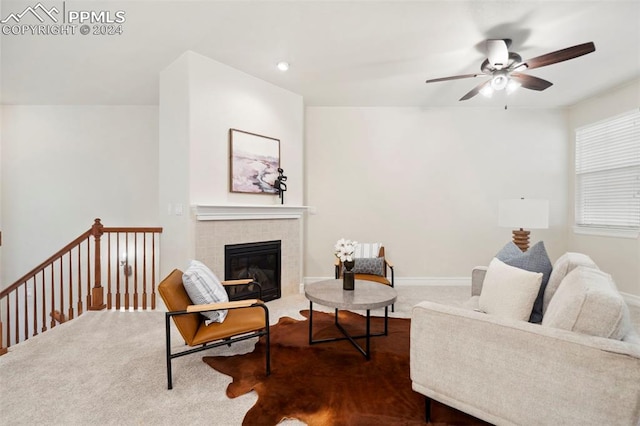 carpeted living room featuring ceiling fan and a fireplace