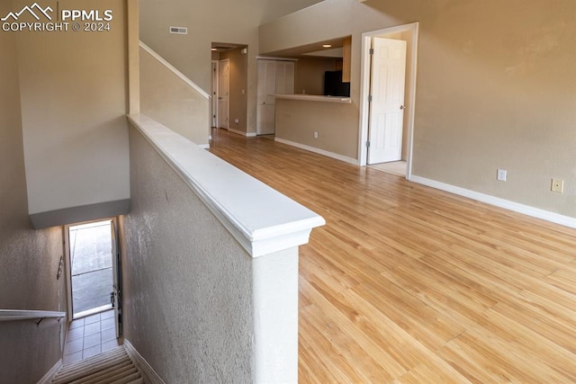 staircase featuring wood finished floors, visible vents, and baseboards