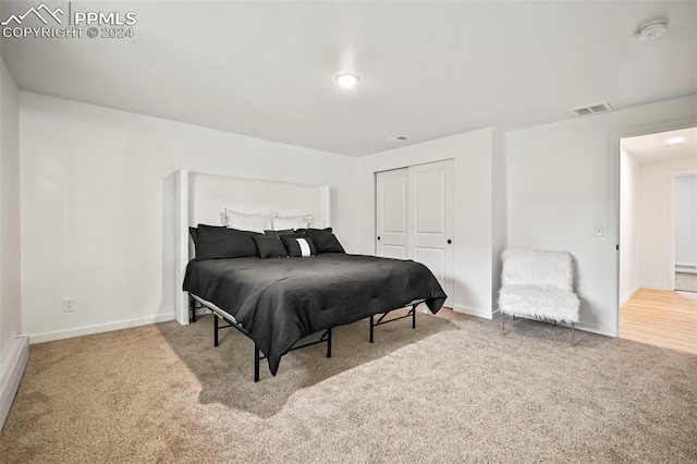 carpeted bedroom with a closet, visible vents, and baseboards