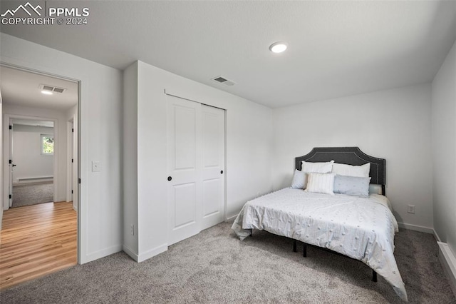 bedroom with carpet, a closet, visible vents, and baseboards