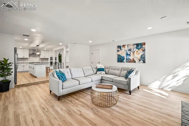 living room with light wood-style floors, recessed lighting, and visible vents