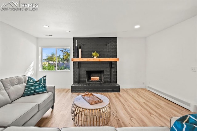 living room featuring a baseboard radiator, recessed lighting, wood finished floors, visible vents, and a brick fireplace