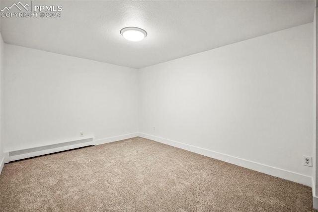 carpeted empty room featuring baseboards and baseboard heating