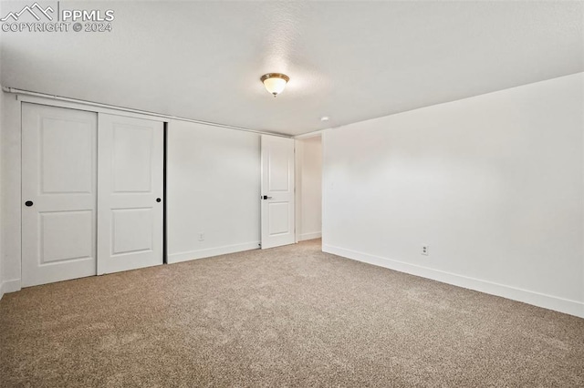 unfurnished bedroom with carpet floors, a closet, and baseboards