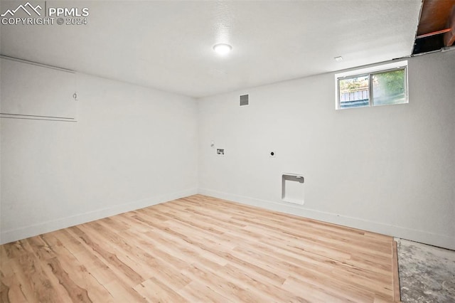 below grade area with wood finished floors, visible vents, and baseboards