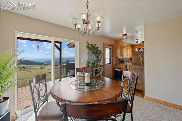 dining area featuring a wealth of natural light, light hardwood / wood-style flooring, a mountain view, and a notable chandelier