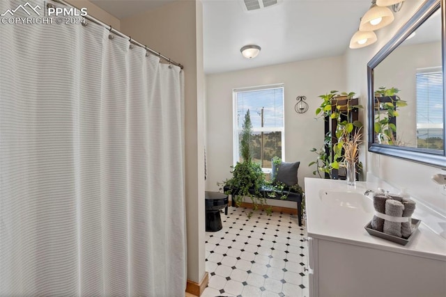 bathroom with toilet, plenty of natural light, and vanity