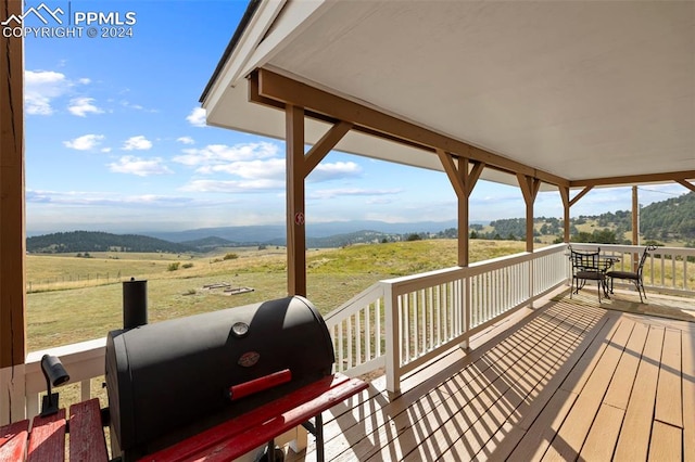 deck with a grill and a rural view