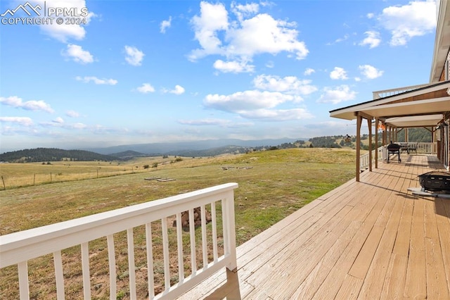 deck with a lawn and a rural view