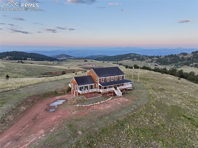 aerial view at dusk with a rural view and a mountain view