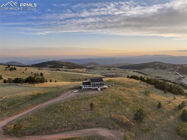 aerial view at dusk with a mountain view and a rural view