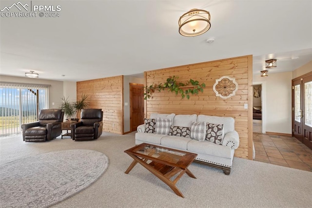 carpeted living room with wood walls