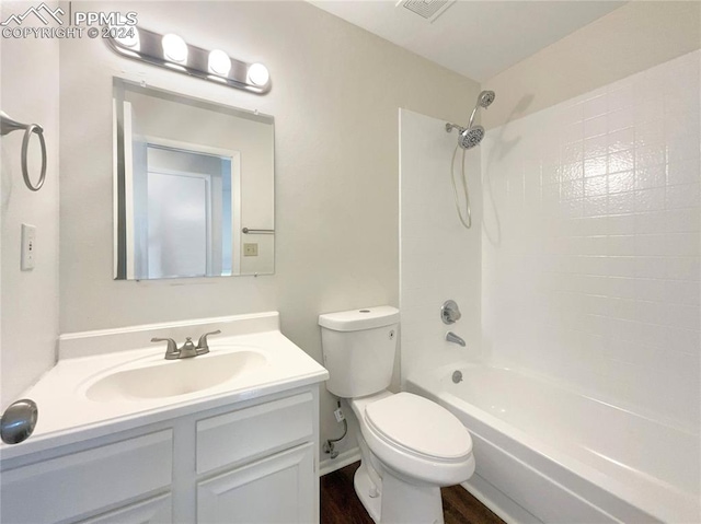 full bathroom featuring tiled shower / bath, toilet, hardwood / wood-style flooring, and vanity