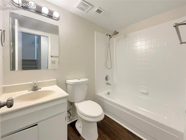 full bathroom featuring washtub / shower combination, toilet, hardwood / wood-style flooring, and vanity