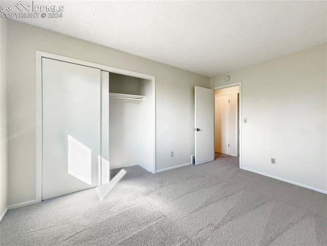 unfurnished bedroom featuring a closet and carpet flooring