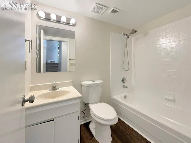 full bathroom with vanity, toilet, hardwood / wood-style floors, and shower / tub combination