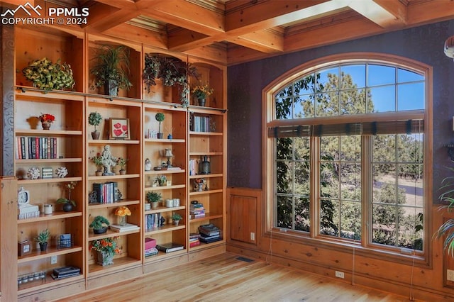 interior space featuring beamed ceiling, coffered ceiling, and light hardwood / wood-style flooring